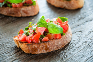 Italian tomato bruschetta with chopped vegetables herbs and oil on grilled or toasted crusty ciabatta bread